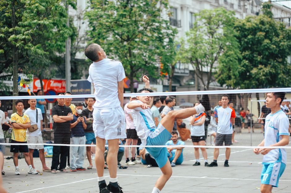 Exciting sepak takraw match captured in a vibrant urban setting with engaged spectators.